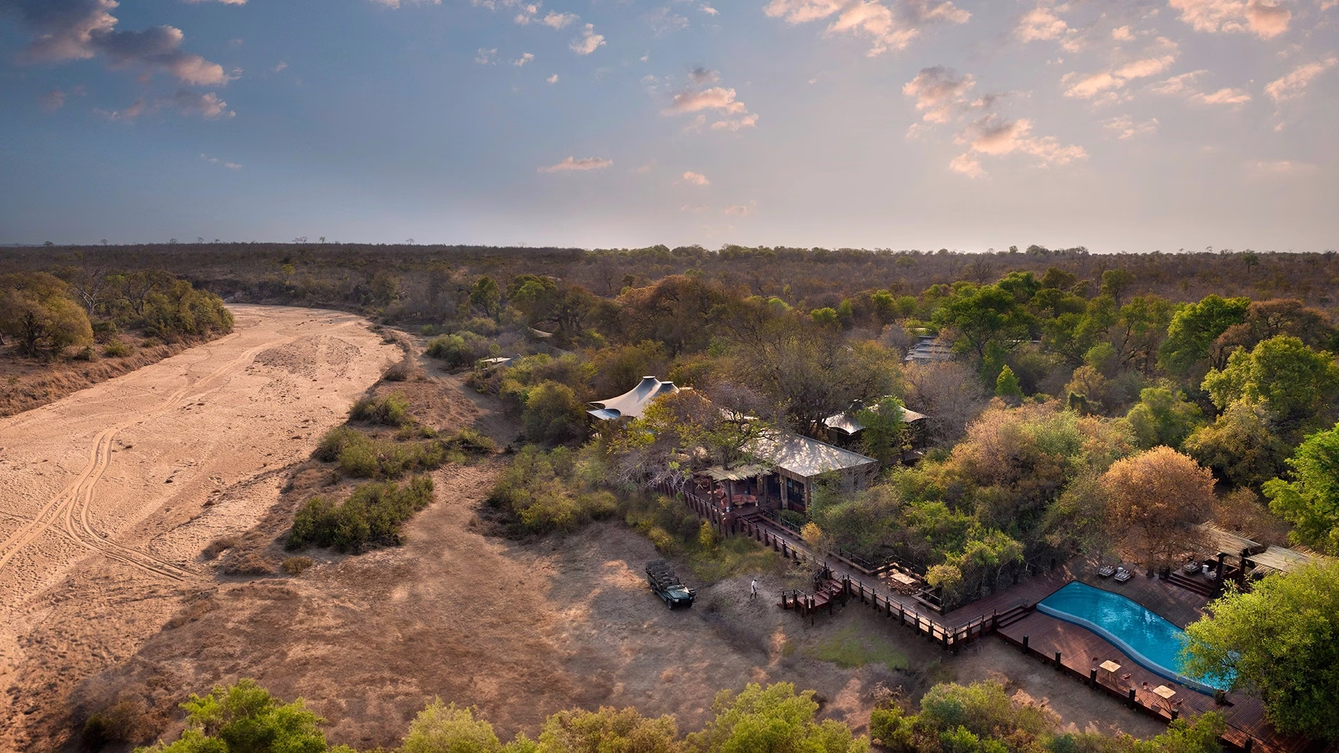Aerial view of Ngala Tented Camp and pool along a dry riverbed