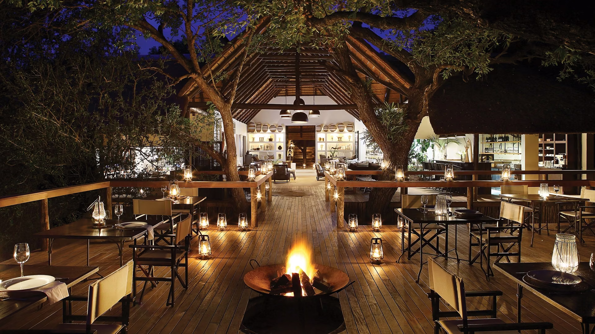 Dinning under the the trees by the light of a campfire and glowing lanterns at Londolozi Tree