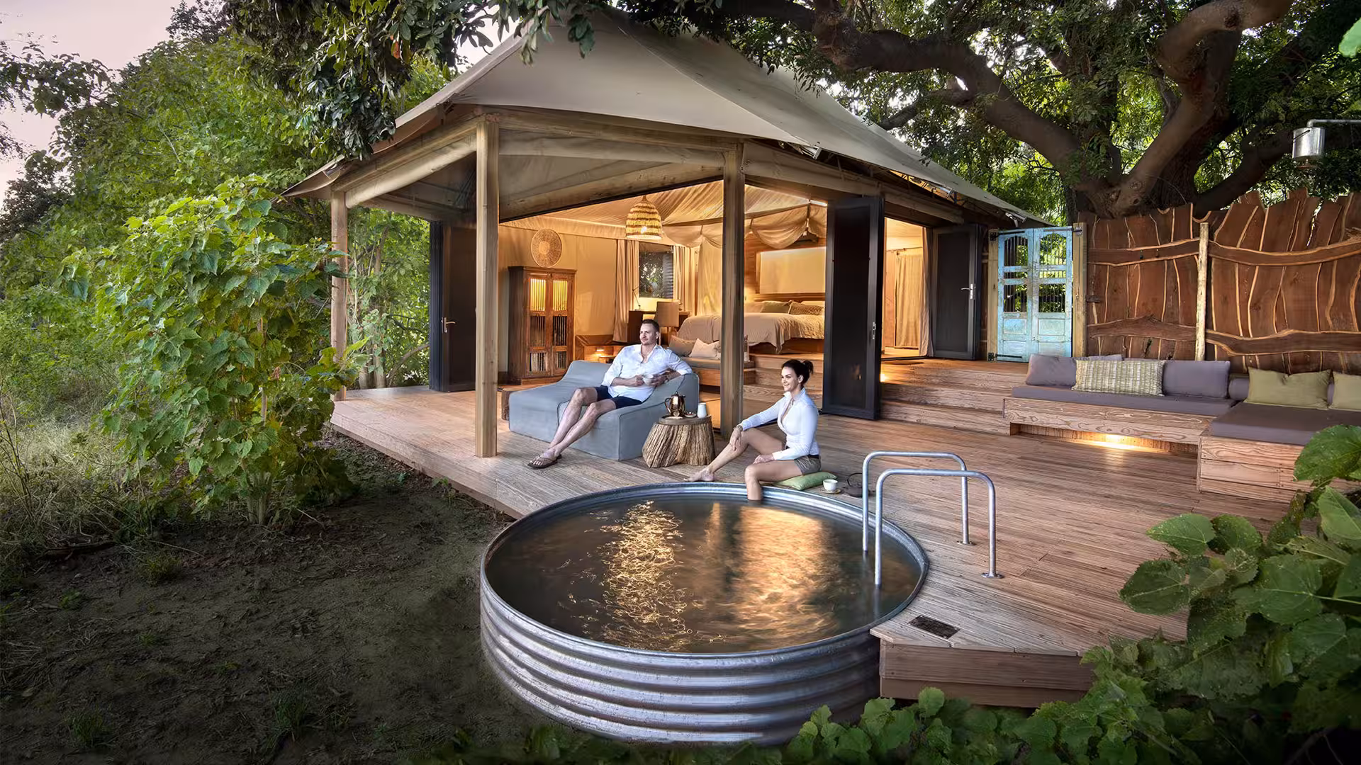 Couple enjoy the views from their deck on safari in Zimbabwe at Nyamatusi safari lodge