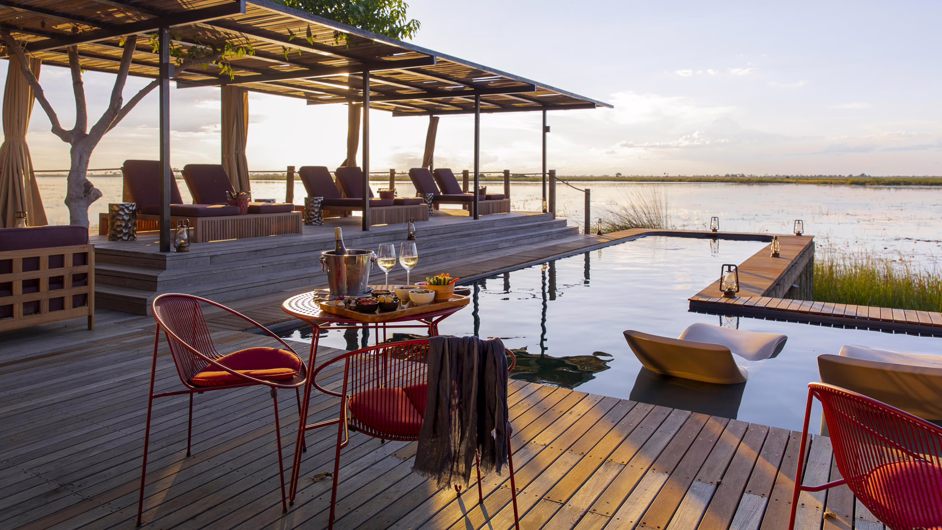 Sunset drinks on the pool deck alongside the water in the Linyanti, Botswana